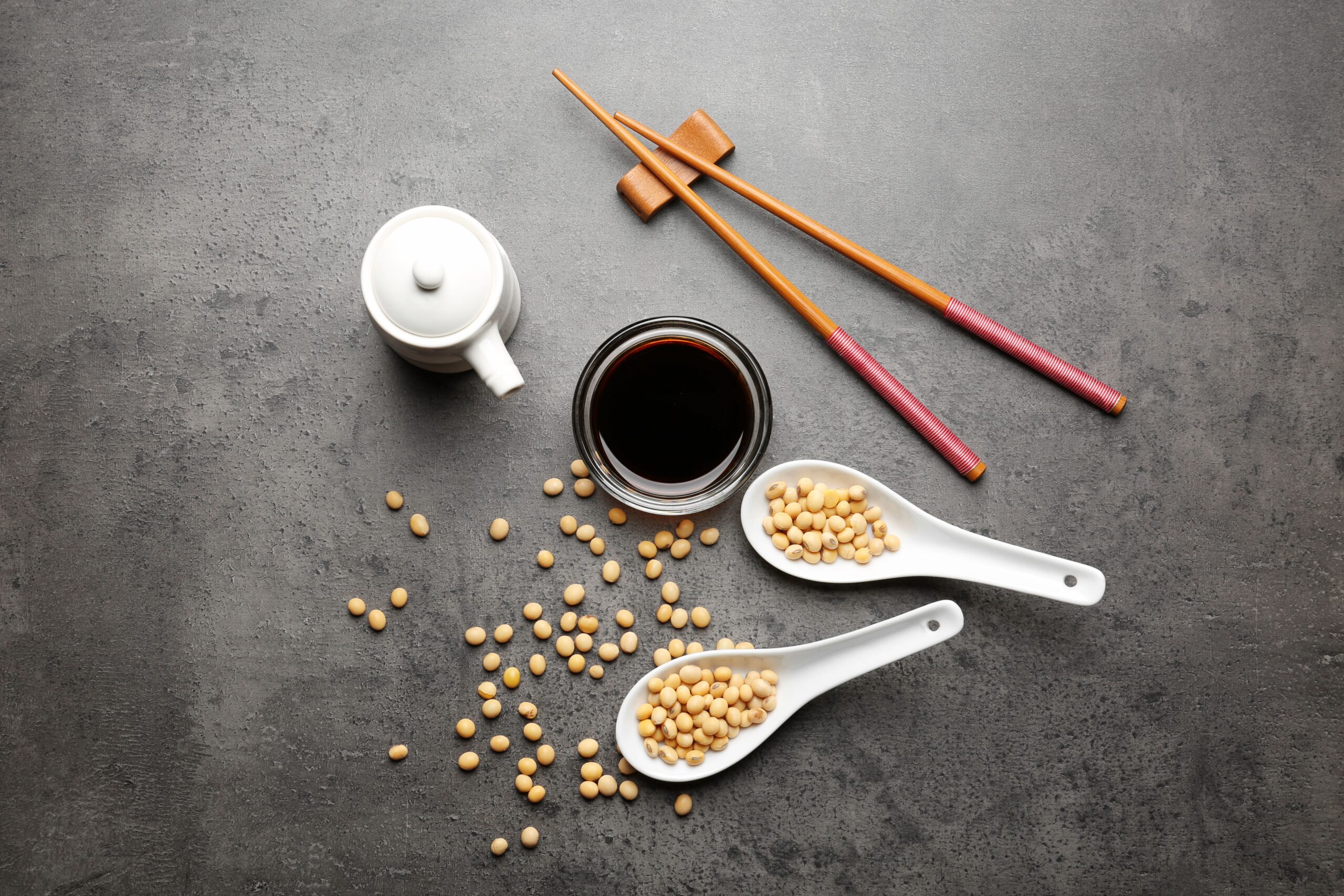 Composition with tasty soy sauce on grey textured background